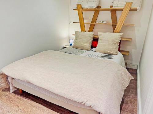 une petite chambre avec un lit avec des draps blancs et des oreillers dans l'établissement Modern Apartment & Parking, à Villeurbanne