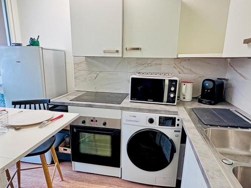 La cuisine est équipée d'un four micro-ondes et d'un lave-vaisselle. dans l'établissement Modern Apartment & Parking, à Villeurbanne