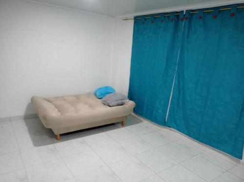 a couch in a room with a blue curtain at Encanto urbano in Moniquirá