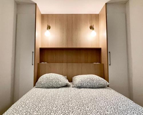 une chambre avec un lit avec deux oreillers dessus dans l'établissement Belsuite Appartement - Parking - Hyper Centre - Ascenseur, à Rennes