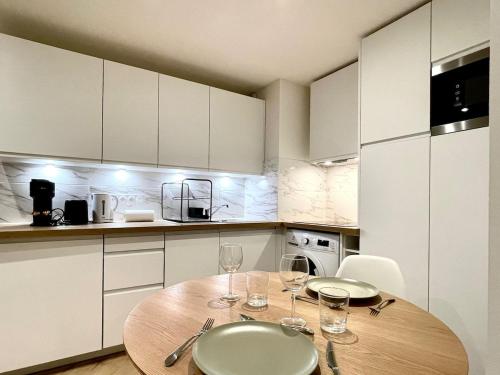 - une cuisine avec une table en bois et des verres à vin dans l'établissement Belsuite Appartement - Parking - Hyper Centre - Ascenseur, à Rennes