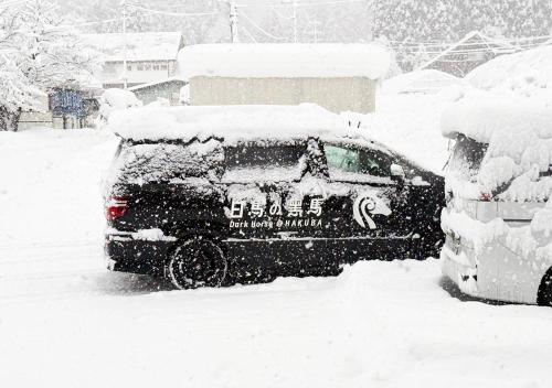 a snow covered car parked in a parking lot at 白馬の黒馬　DarkHorse @Hakuba in Hakuba