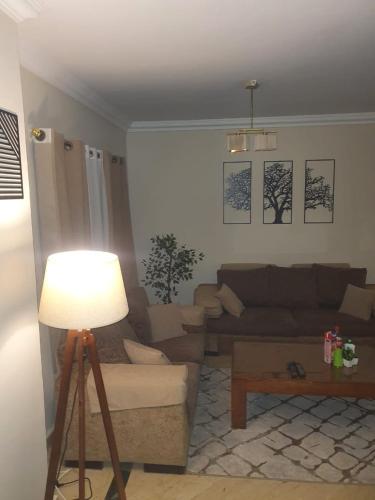 un soggiorno con un divano e un tavolo di TREE Serviced Apartment -2BHK Self check-in a Il Cairo