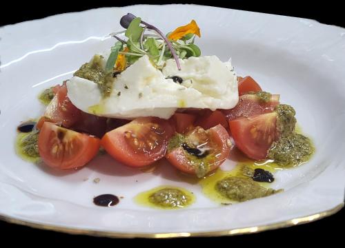 a plate of food with tomatoes and cheese on it at HOTEL PASTERAL RIU TER in La Cellera de Ter