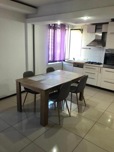 a kitchen with a wooden table and chairs at Centru in Piteşti