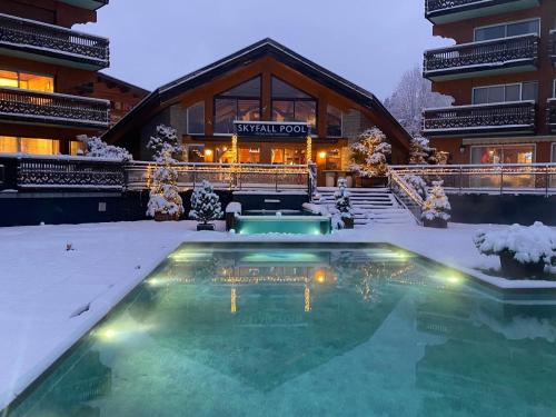レ・ジェにあるHôtel Le Labrador 1971の建物前の雪中のスイミングプール