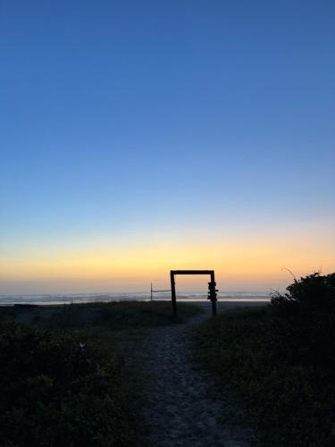 a bench on the beach with the sunset in the background at Pousada Bela Vista in Ilha do Mel