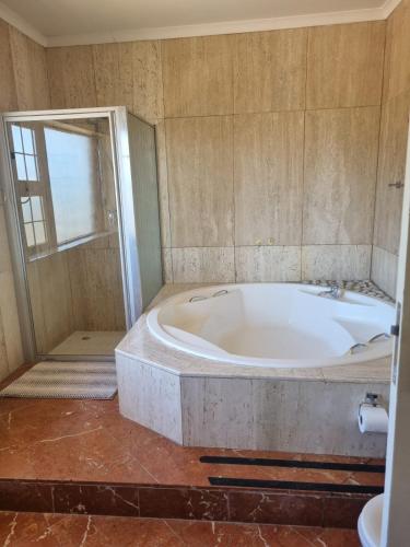 a bathroom with a large tub and a shower at Grace Space in Plattekloof in Cape Town