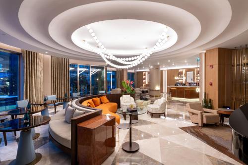 a lobby with a couch and chairs and a chandelier at Ramada Plaza By Wyndham Istanbul City Center in Istanbul