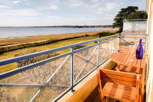 a balcony with a bench and a blue vase at La Baie - vue sur la plage in La Forêt-Fouesnant