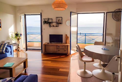 a living room with a view of the ocean at La Baie - vue sur la plage in La Forêt-Fouesnant