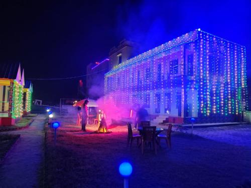 a group of people standing in front of a building with christmas lights at Sea Smile Inn in Mandarmoni