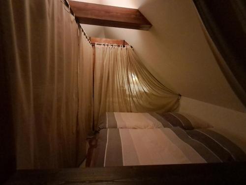 a small bed in a room with a curtain at House in nature in Broby