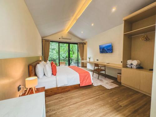 a hotel room with a bed and a desk at Arunika Villa in Ciloto