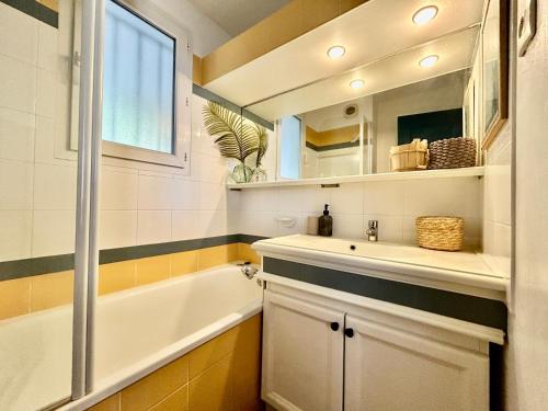 une salle de bain avec une baignoire et un lavabo et une baignoire dans l'établissement Les Restanques Roses 1178 vue mer, à Grimaud