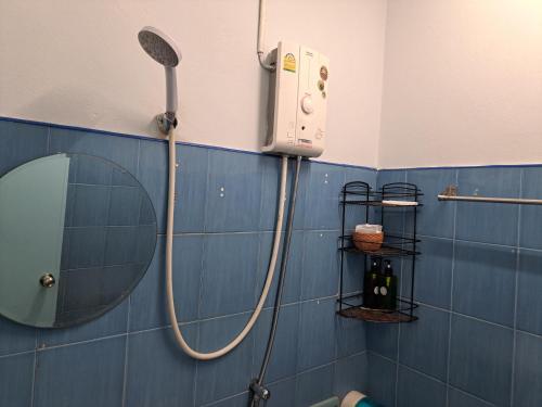 a blue tiled bathroom with a shower and a mirror at whole house for 5 guests 3 beds in Hat Yai