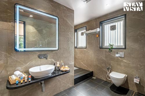 a bathroom with a sink and a mirror at StayVista at The Grand Crest - Presidential Suite in Karjat