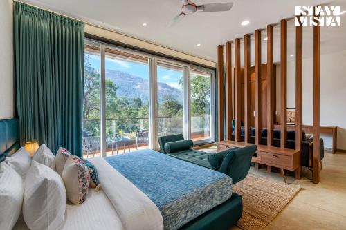 a bedroom with a bed and a large window at StayVista at The Grand Crest - Presidential Suite in Karjat