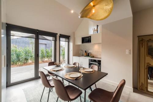 une salle à manger avec une table et des chaises noires dans l'établissement Magnifique maison de campagne en Bretagne, à Saint-Brandan