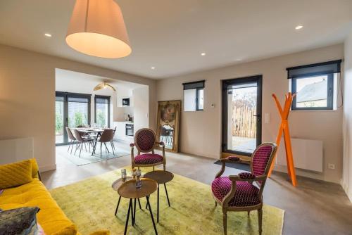 un salon avec un canapé, des chaises et une table dans l'établissement Magnifique maison de campagne en Bretagne, à Saint-Brandan