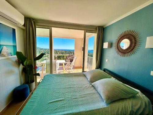 - une chambre avec un lit et un balcon dans l'établissement Les Restanques Roses 1178 vue mer, à Grimaud