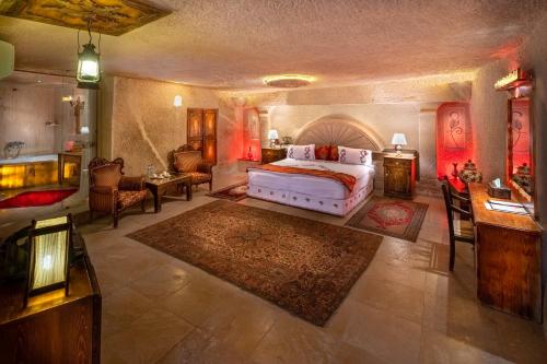 a bedroom with a bed and a living room at Cappadocia Gamirasu Cave Hotel in Urgup