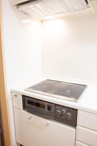 a stove top oven in a kitchen with white cabinets at 杏々anan in Kagoshima