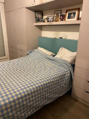 - une petite chambre avec un lit doté d'une tête de lit bleue dans l'établissement Superbe 3 pièce jardin, aux Lilas