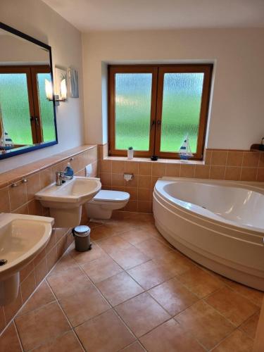 a bathroom with a tub and a toilet and a sink at Haus Inselglück in Fehmarn