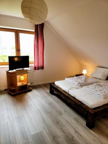 a bedroom with a bed and a flat screen tv at Haus Inselglück in Fehmarn