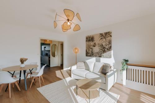a living room with a white couch and a table at Appartement T2 cosy - Garage privé - WiFi in Chambéry