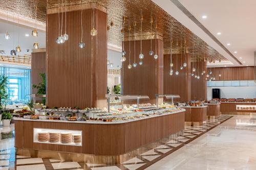 una línea de buffet en un restaurante con lámparas de araña en Merit Park Hotel Casino & SPA, en Kyrenia
