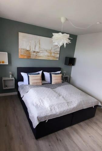 a bedroom with a large bed with a white ceiling at Hafenglück in Fehmarn