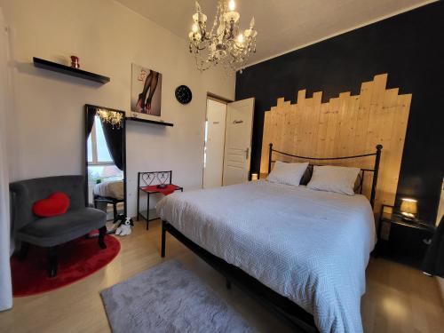 - une chambre avec un lit, une chaise et un lustre dans l'établissement GÎTE PRIVATIF, MAISON DE VACANCES FAMILIALE 100m2 avec piscine, parking privé 