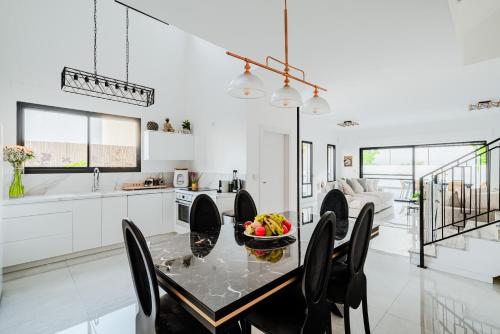 a kitchen and dining room with a table and chairs at לגונה בלו ביץ-וילה מהממת עם בריכה פרטית וג'קוזי דקה מהים in H̱adera