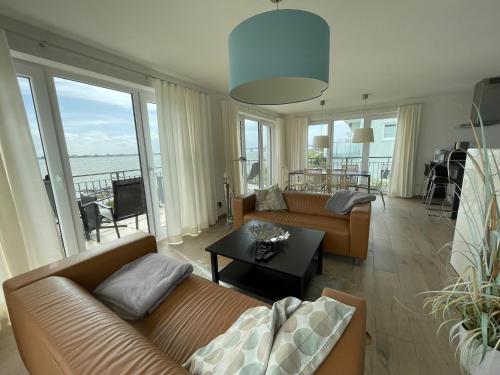 a living room with couches and a view of the ocean at Ferienresidenz Haus Vogelflug Strandresidenz Vogelflug App 17 in Fehmarn