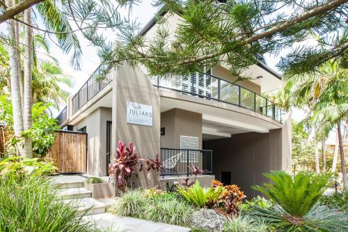 a house with a sign on the front of it at Julians Apartments in Byron Bay