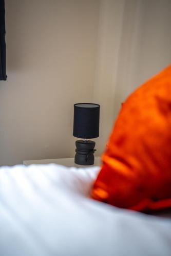 a black lamp sitting on top of a bed at Anderson Apartment in Airdrie