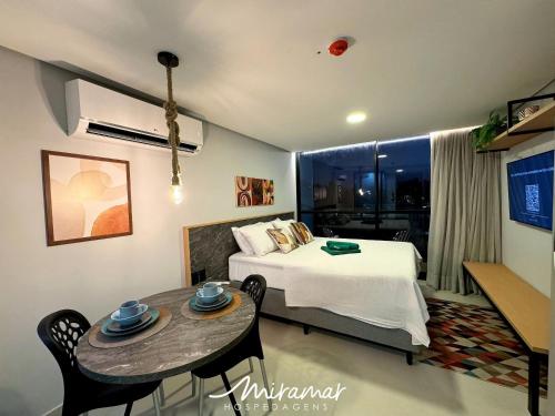 a bedroom with a bed and a table with chairs at Alta Garden- Pé Na Areia- MH in João Pessoa