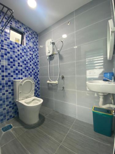 a bathroom with a toilet and a sink at MERCU STAYCATION HOMESTAy in Lengging