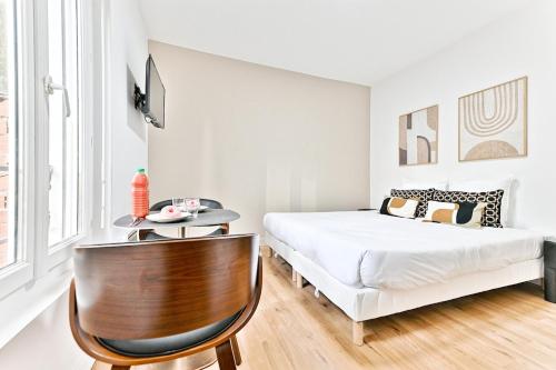 une chambre avec un lit, une table et une chaise dans l'établissement Petit studio paisible en région parisienne -II, à Asnières-sur-Seine
