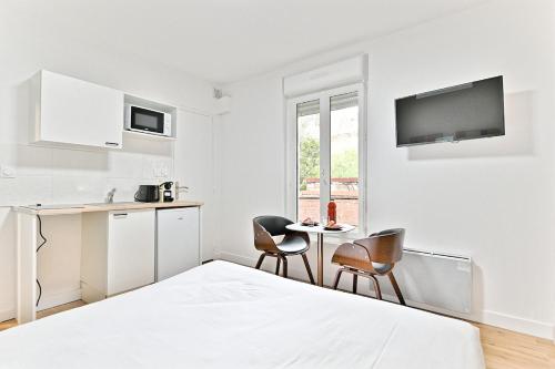 - une chambre blanche avec un lit et deux chaises dans l'établissement Petit studio paisible en région parisienne -II, à Asnières-sur-Seine