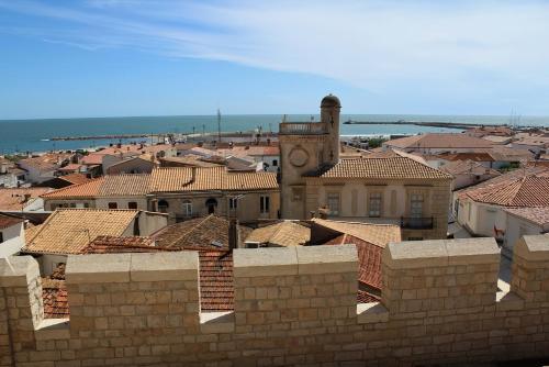a view of a city with a clock tower and roofs at Mas de la Fouque - Hôtel & Spa in Saintes-Maries-de-la-Mer