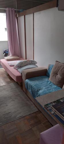 a room with three beds and a couch at Luz de Regina Hospedagem in Salvador