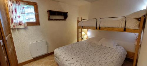 une chambre avec deux lits superposés et une fenêtre dans l'établissement Appartement skis aux pieds Méribel-Mottaret avec garage et wifi, à Méribel