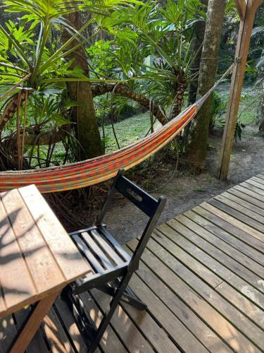 a hammock sitting next to a table and a bench at Pousada Bela Vista in Ilha do Mel