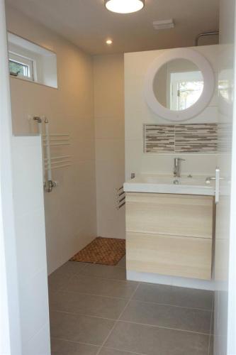 a bathroom with a sink and a mirror at The Beach House in Noordwijkerhout