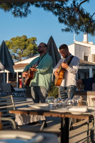 two men are playing instruments at a table at Mas de la Fouque - Hôtel & Spa in Saintes-Maries-de-la-Mer