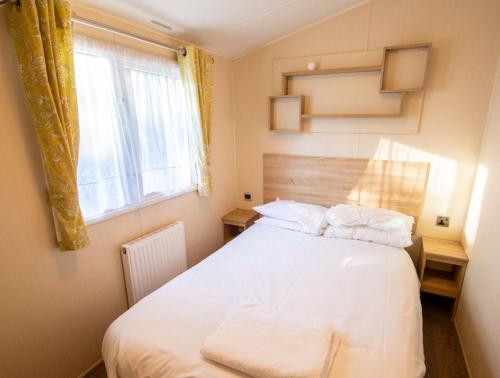 a bedroom with a white bed and a window at Gardens 3 - Coghurst Hall Hastings in Westfield