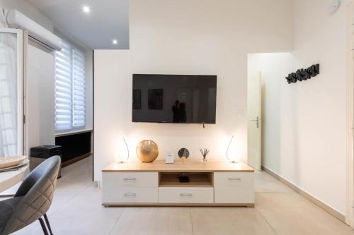 un salon avec une télévision sur un mur blanc dans l'établissement Renovated Apartment in the Heart of Cannes, à Cannes